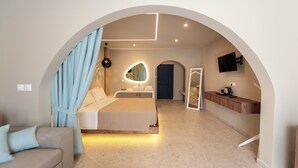 A modern bedroom with a large bed, a bathroom with a mirror, and a TV mounted on the wall. - Fantasy (Rhodes)