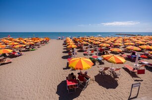 Una playa cerca, sillas reclinables de playa, sombrillas