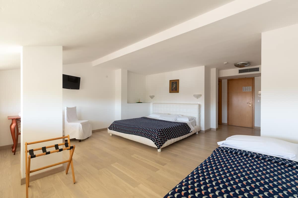 A modern bedroom with a bed, a chair, and a desk.
