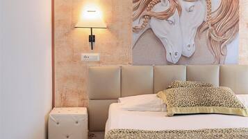 Un dormitorio con cama, mesita de noche, lámpara de pared y un cuadro grande de caballos.
