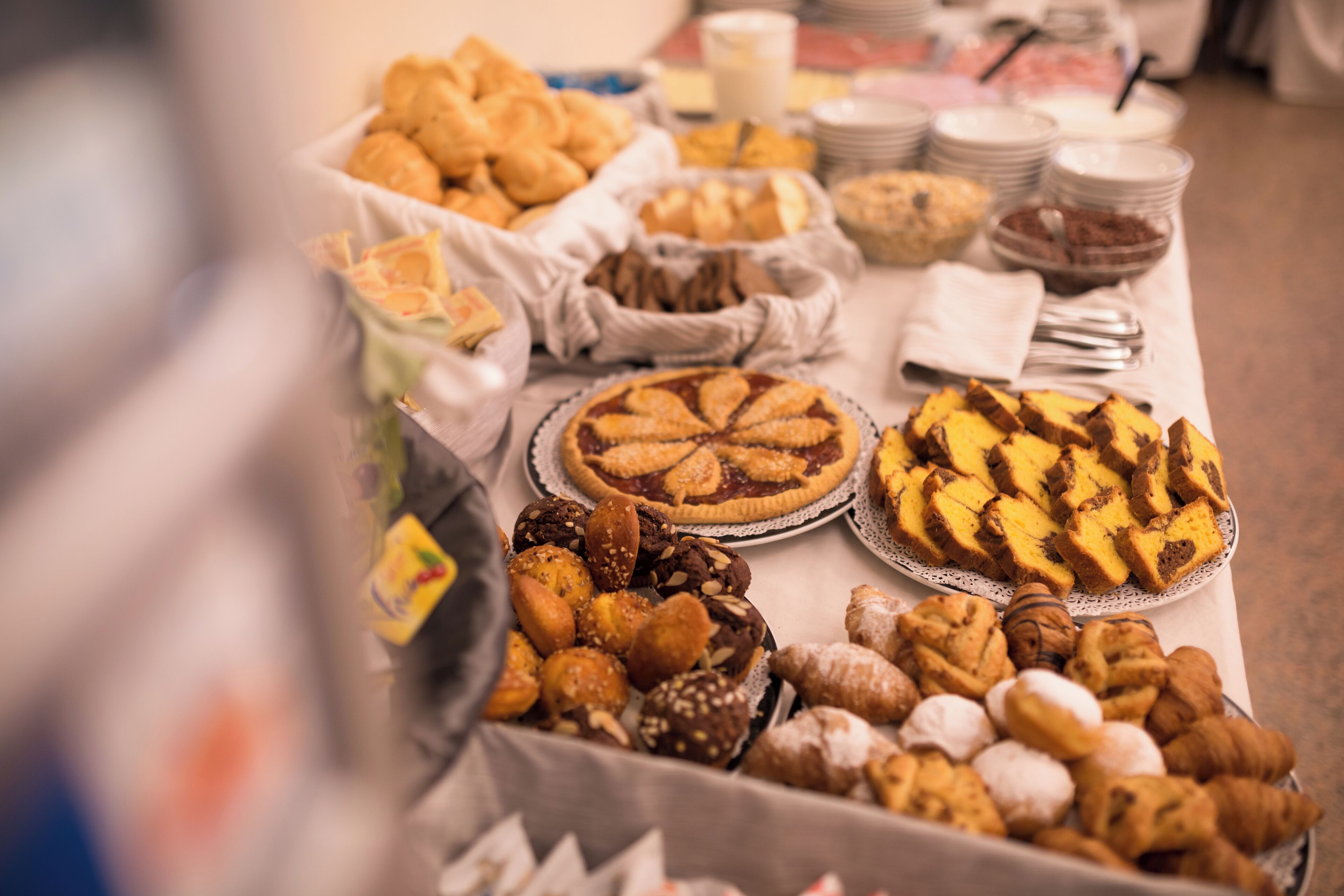 A buffet table with various baked goods and pastries.