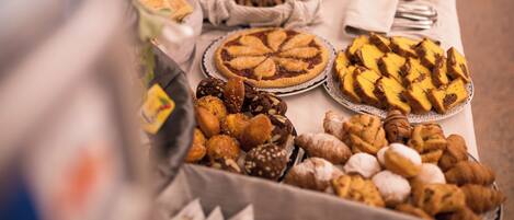 A buffet table with various baked goods and pastries.