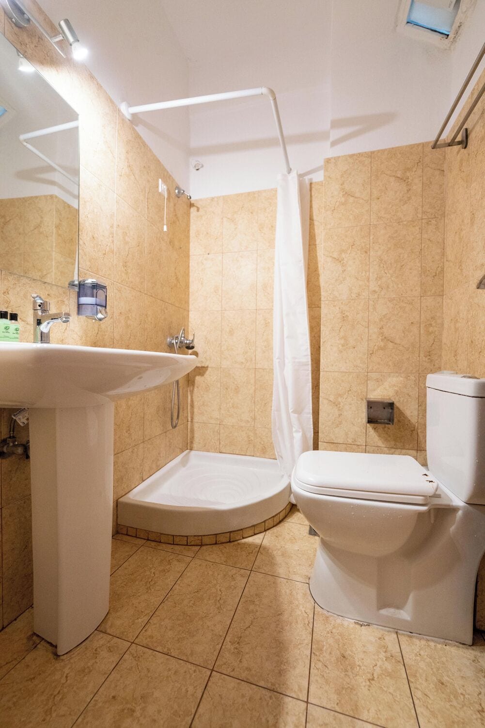 A bathroom with a sink, toilet, and shower.