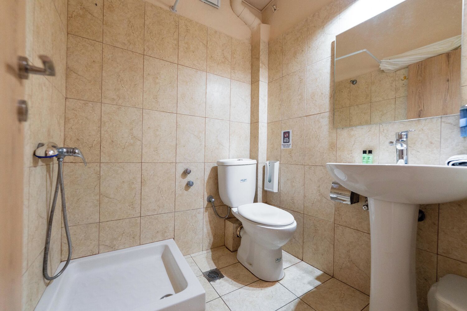 A bathroom with a toilet, sink, and shower.