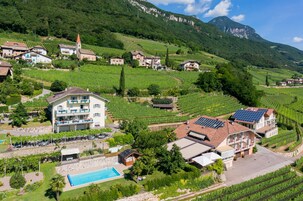 Una propiedad en la ladera con piscina, paneles solares y vistas a viñedos.