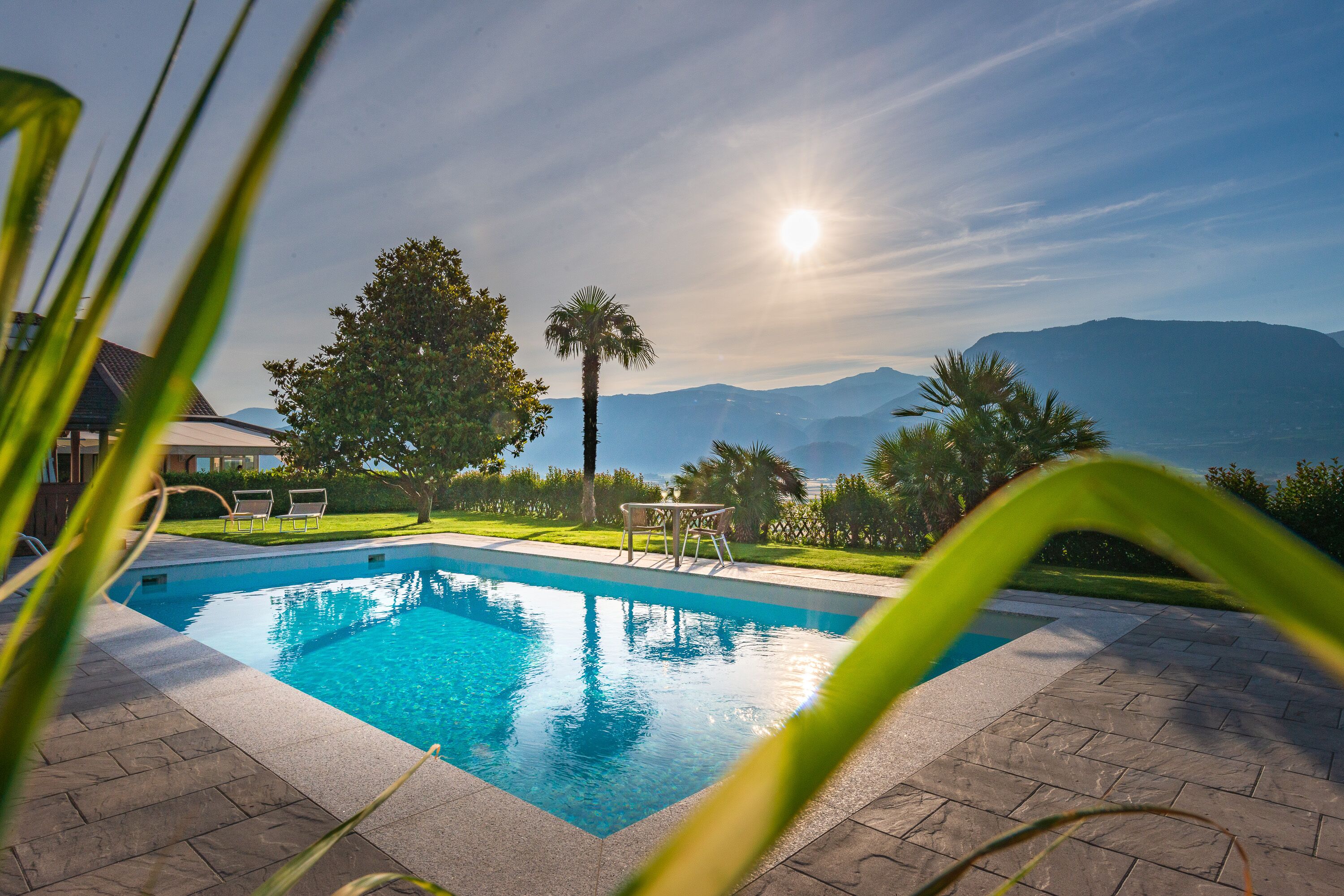 Une piscine offrant une vue sur les montagnes et un ciel dégagé.