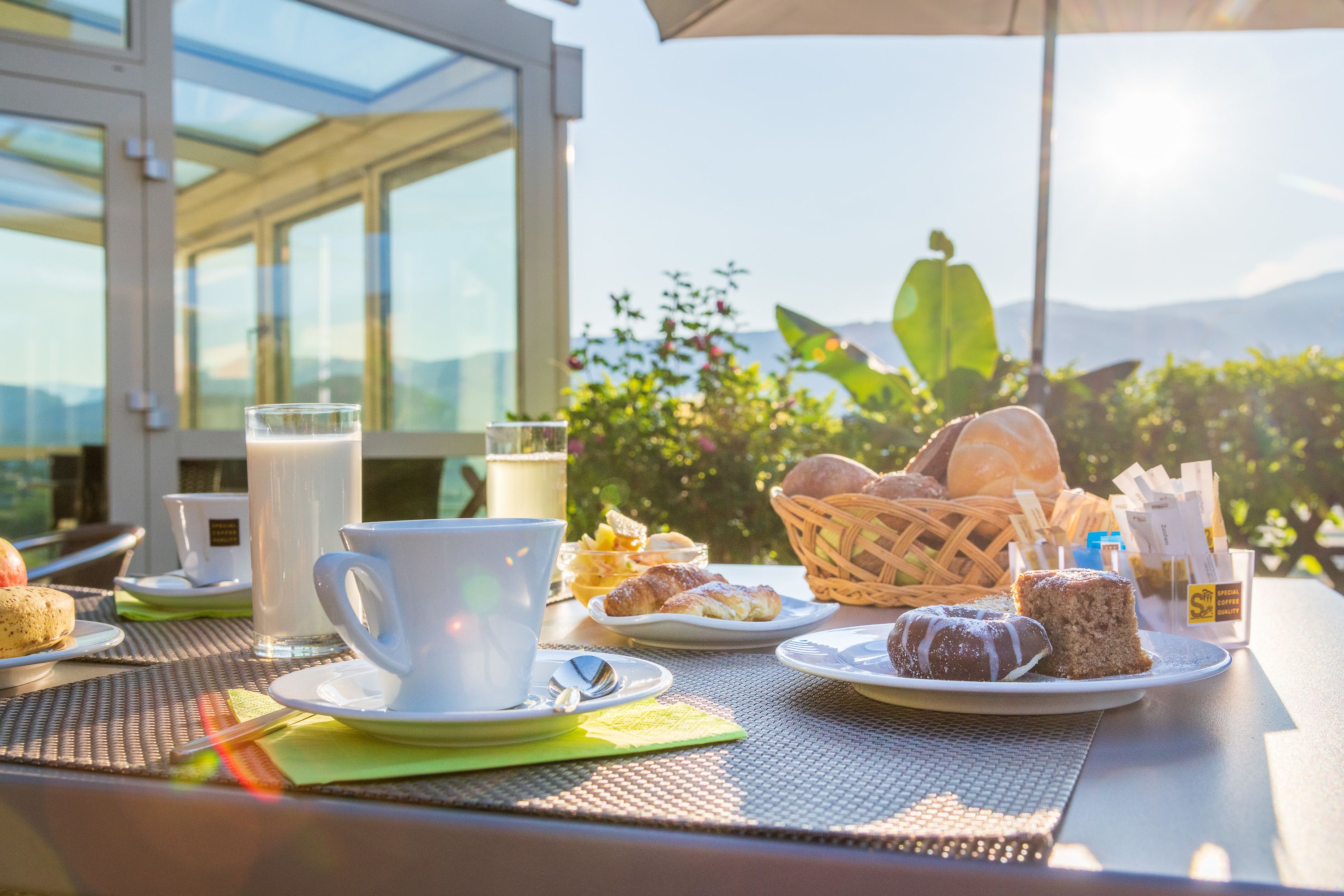 Una mesa con platos, tazas y pasteles para el desayuno.