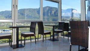 A terrace with wicker chairs and a table, overlooking a mountainous landscape. - Garni Hotel Ritterhof (Termeno Sulla Strada del Vino)