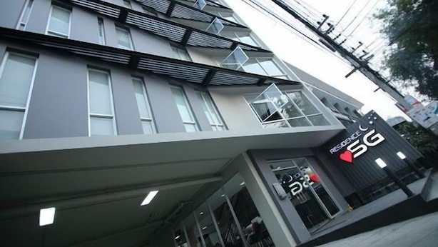 Un edificio moderno con un cartel de 5G, ventanas amplias y fachada plana.
