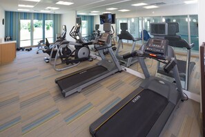A gym with treadmills, stationary bikes, and a weight bench area.