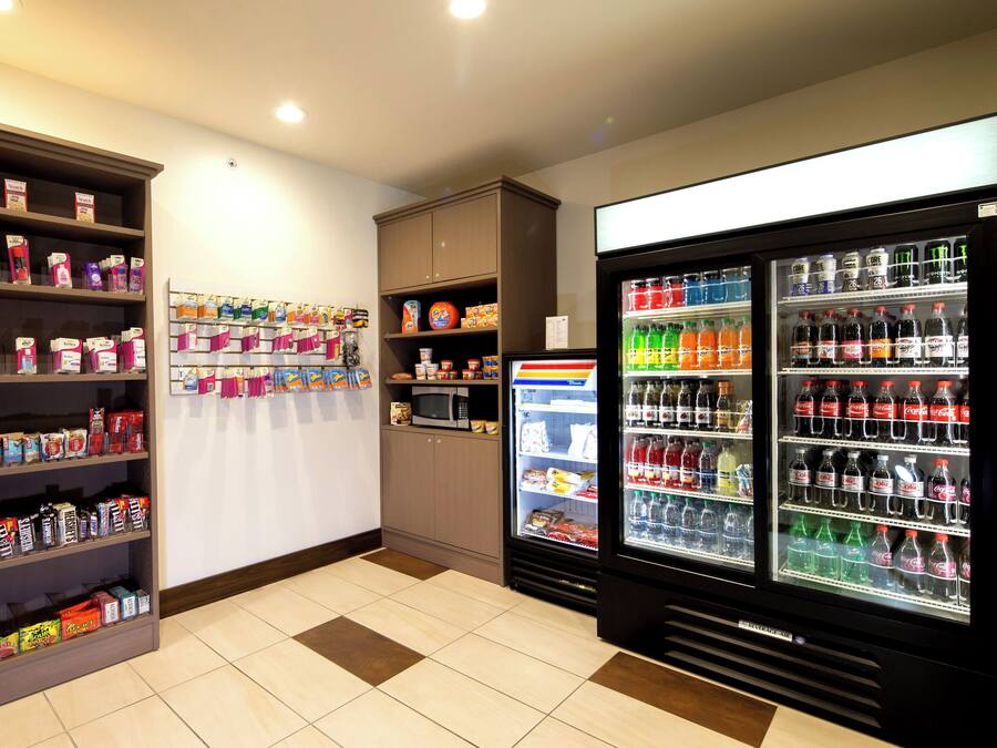 Zona de máquinas expendedoras con opciones de bocadillos y bebidas, que incluye microondas y refrigeradores.