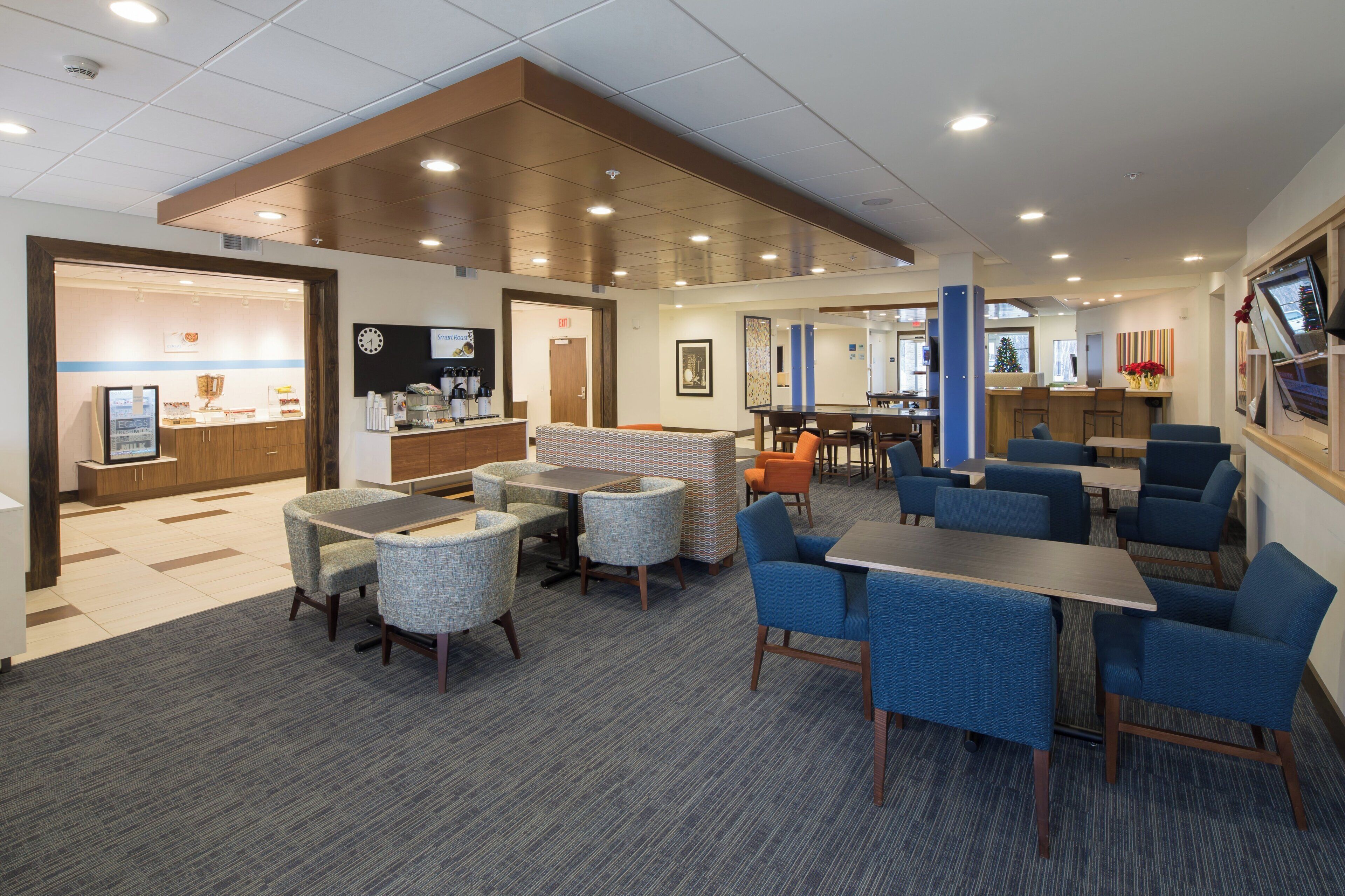 A hotel lobby with seating areas, a reception desk, and a Christmas tree.