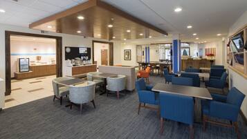 A hotel lobby with seating areas, a reception desk, and a Christmas tree.
