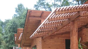 A wooden cabin with a stone pathway leading to the entrance. - Cabañas El Estribo Hotel (Valle de Bravo)