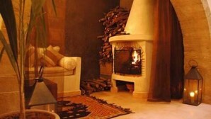 Une pièce chaleureuse avec une cheminée, un canapé et une lampe.