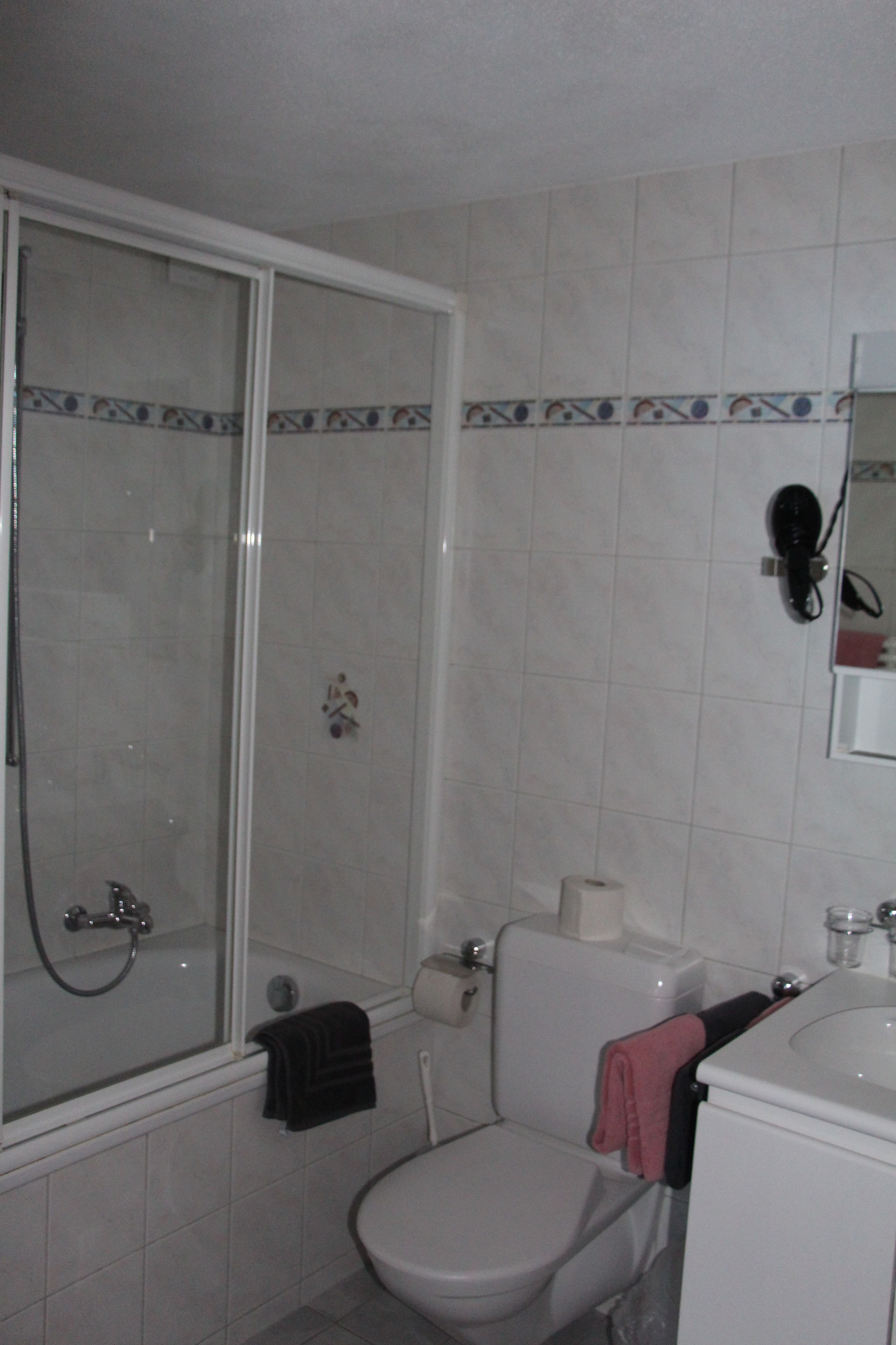 Un baño con ducha, inodoro y lavamanos.