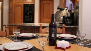 A dining table set with plates, wine glasses, and a candle. - Apartments Arcadia (Saas Grund)