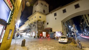 A historic building with a tower, a cafe, and a car parked in front. - Torre Mannelli Suites (Florence)
