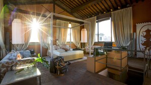 A spacious room with a bed, a sofa, a desk, and a balcony. - Torre Mannelli Suites (Florence)