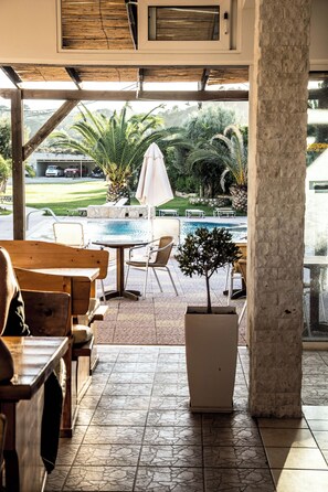 An outdoor seating area with a pool, chairs, and a potted plant. - Sevastos Studios (Rhodes)