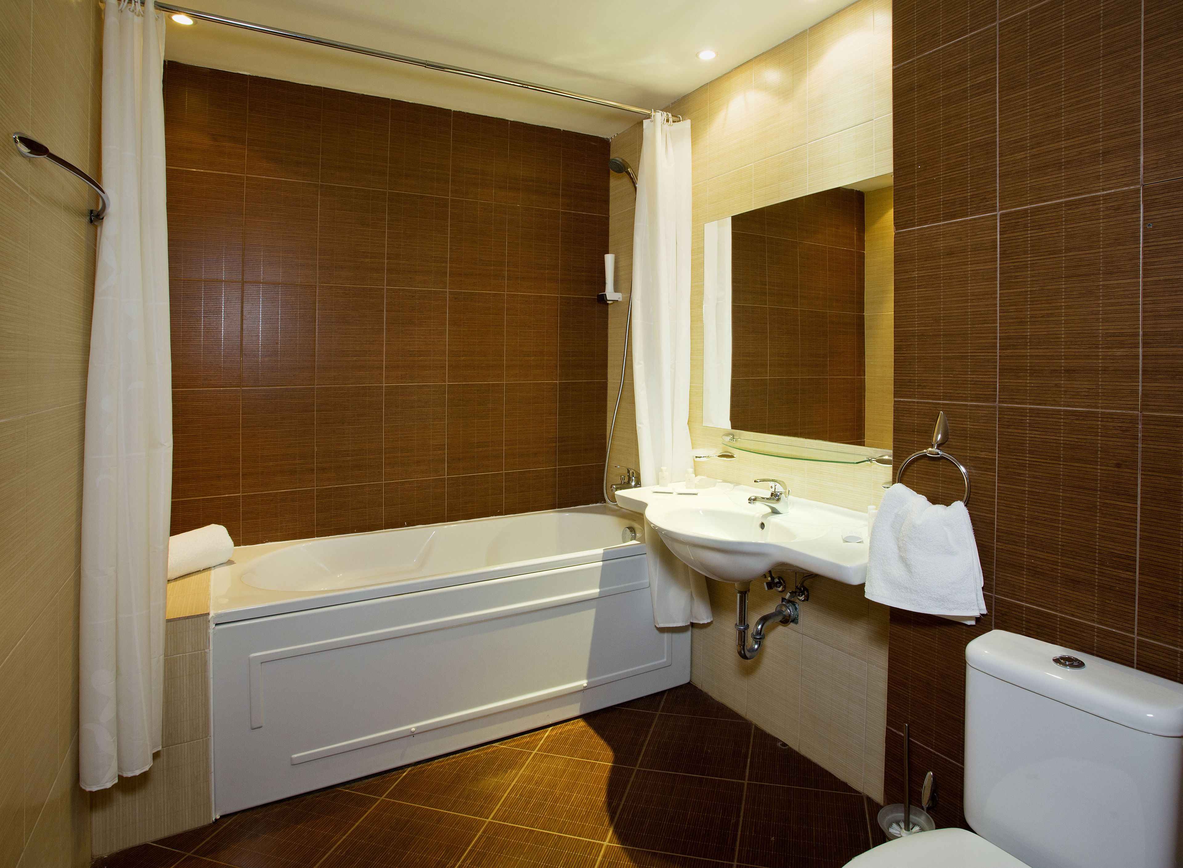A modern bathroom with a bathtub, sink, and toilet.