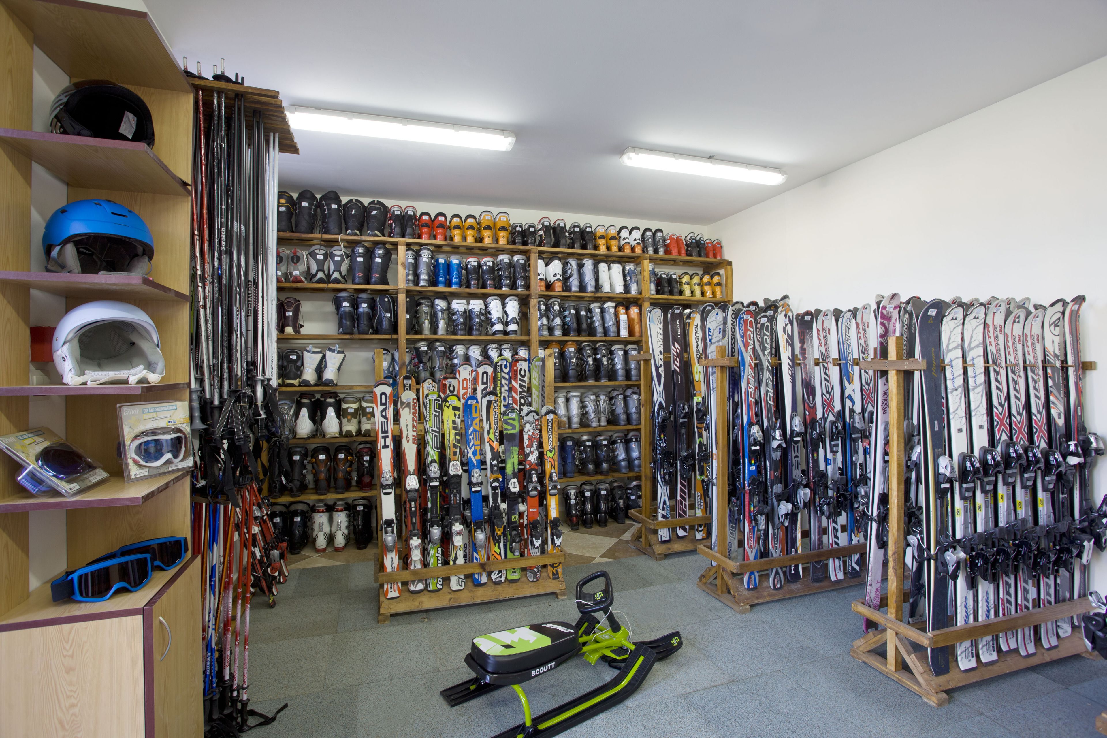 Tienda de equipo de esquí con estantes llenos de esquíes, tablas de snowboard y cascos.