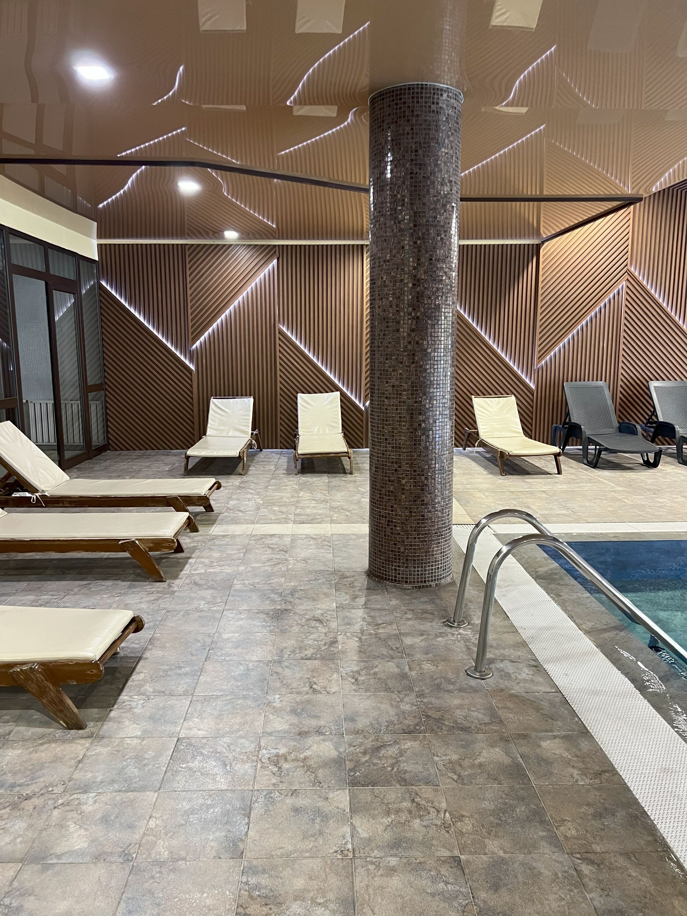 Una piscina techada, sillones reclinables de piscina