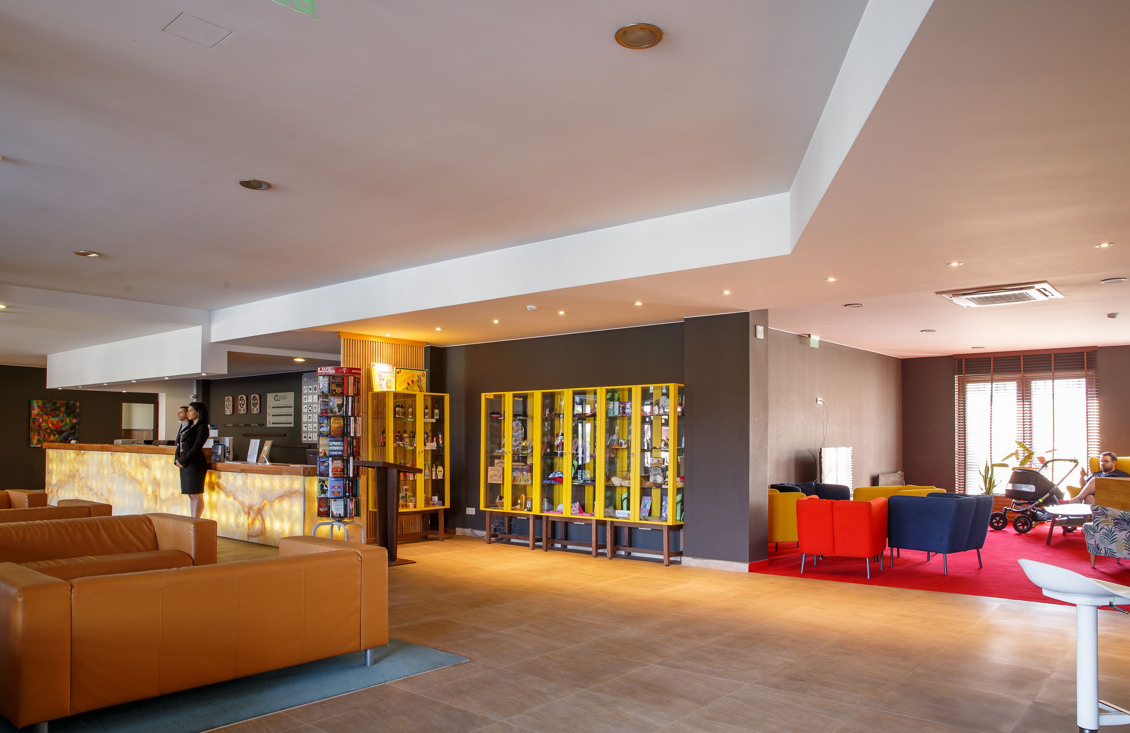 A spacious lobby with a reception desk, seating area, and a display of items.