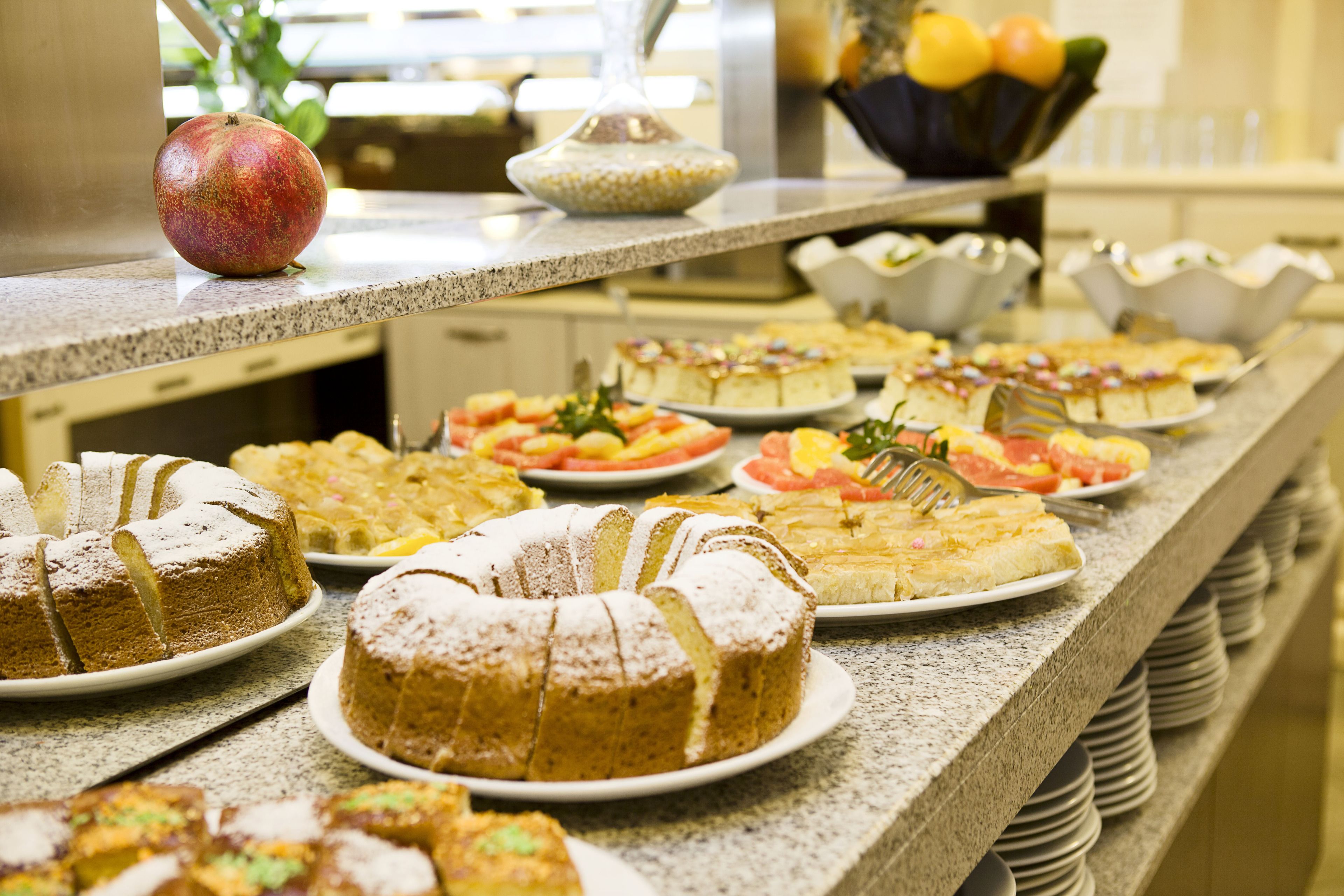 Um buffet com diversos doces e frutas.