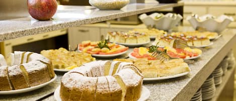 Um buffet com diversos doces e frutas.