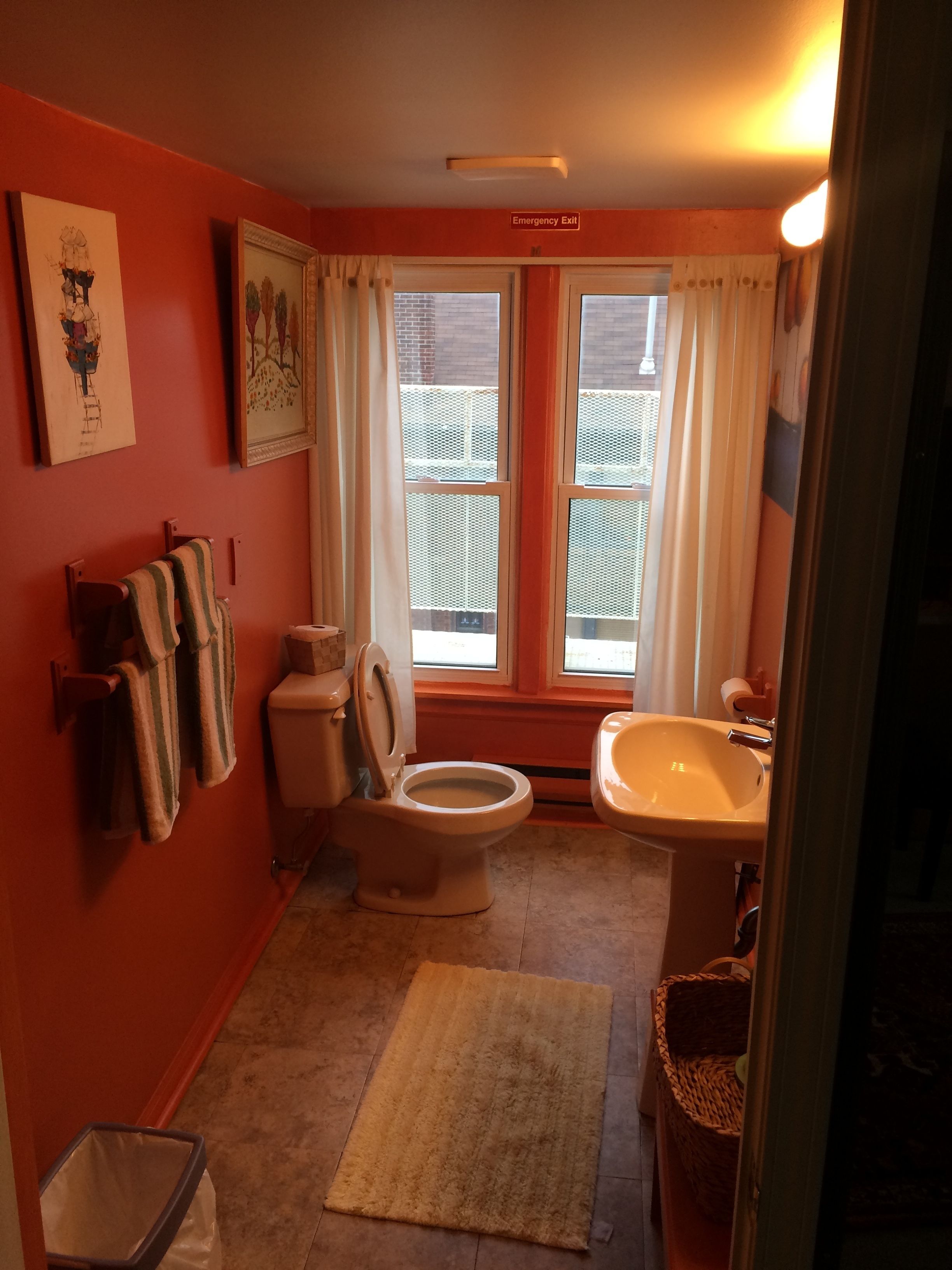 Une salle de bain avec des toilettes, un lavabo et une fenêtre.