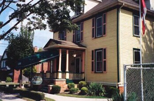 Traditional two-story home with a central entrance, pitched roof, and front porch.