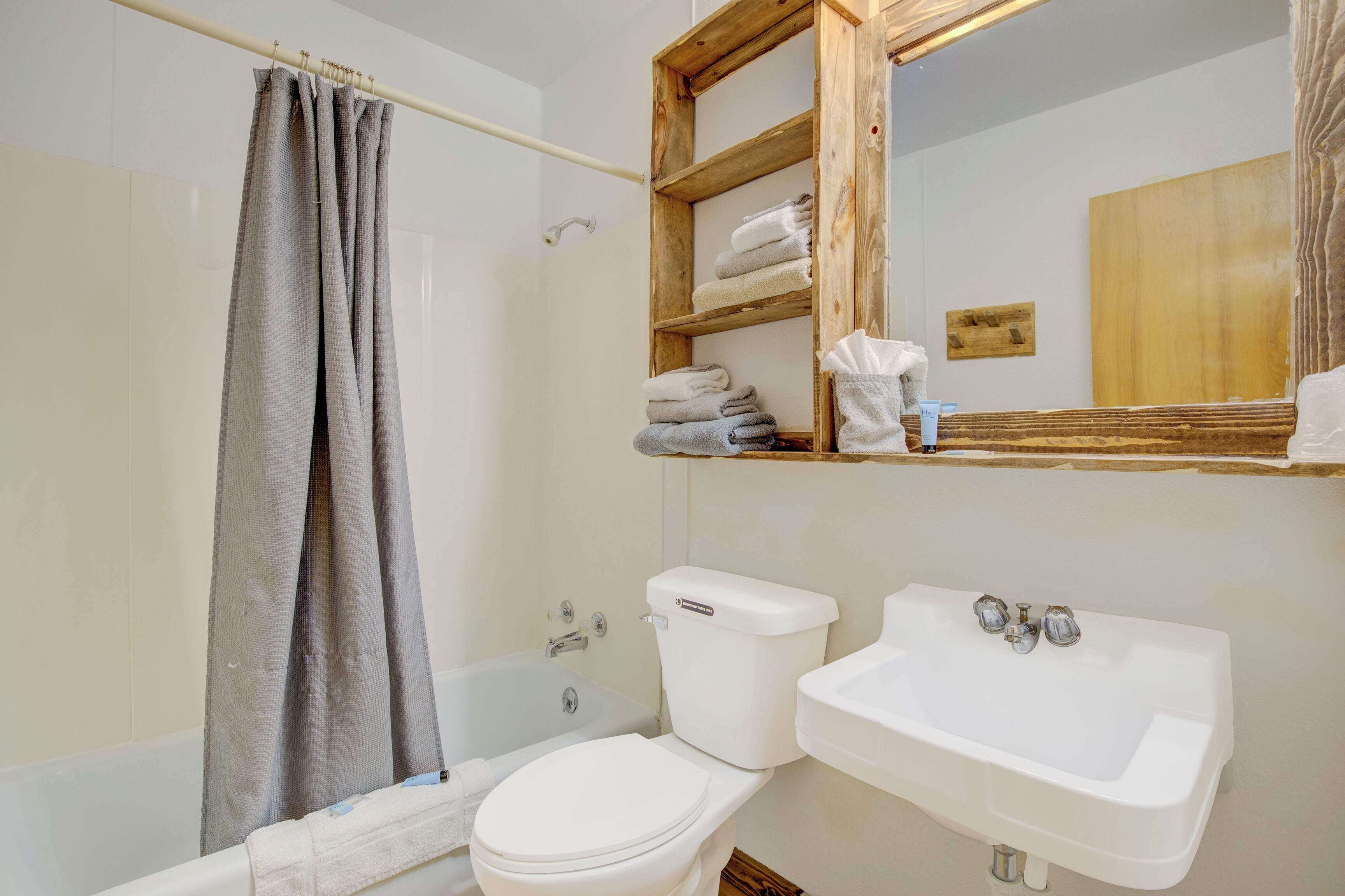 Een badkamer met een bad, toilet en wastafel.