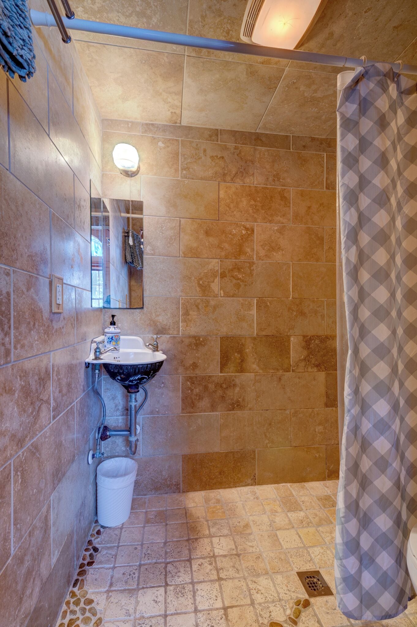 Une salle de bain avec une douche, un lavabo et un miroir.