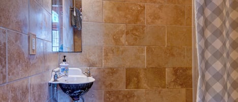 Une salle de bain avec une douche, un lavabo et un miroir.