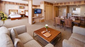 A hotel room with a bed, a TV, a desk, and a dining area. - Sky Star Hotel (Yangon)