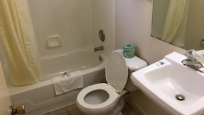 A bathroom with a bathtub, toilet, and sink. - Colonade Motel (Hightstown)
