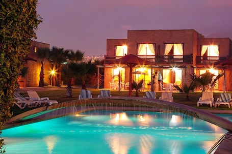 Una piscina al aire libre, sillones reclinables de piscina