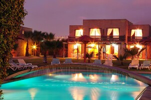 Una piscina al aire libre, tumbonas