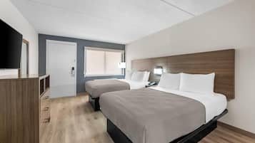 A hotel room with a bed, bedside tables, a desk, and a TV.