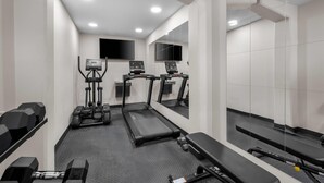 A gym with treadmills, elliptical machines, and free weights.