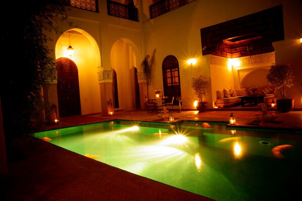 Una piscina al aire libre, sombrillas, tumbonas