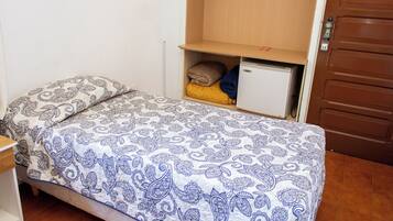 A bedroom with a bed, a nightstand, a wardrobe, and a small cabinet.