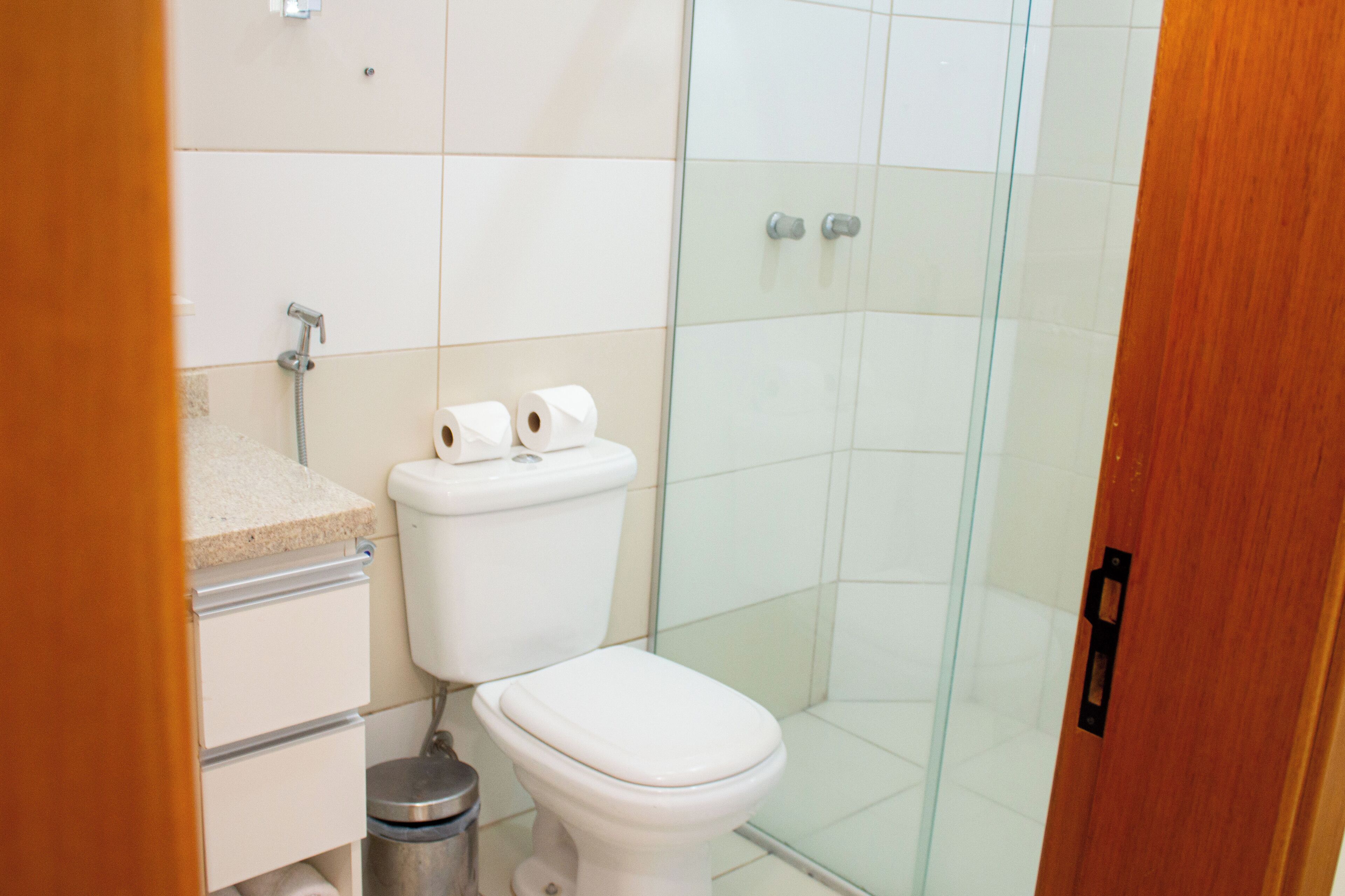 Un baño moderno con inodoro, ducha y tocador.