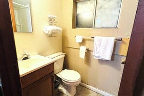 A small bathroom with a toilet, sink, and towel rack. - Sparta Motel Near St. Louis / Mississippi River IL (Sparta)