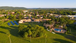 Zona residencial con casas, paneles solares, un parque infantil y una piscina.