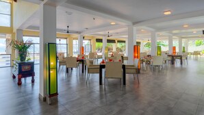 A spacious indoor dining area with high ceilings, large windows, and modern furniture. - Cocobay Unawatuna (Unawatuna)