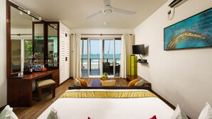 Ein Hotelzimmer mit Bett, Schreibtisch, Stuhl, Fernseher und Meerblick.