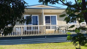 A two-story house with a balcony, a covered porch, and a fenced yard. - Carmens Inn (Scamander)