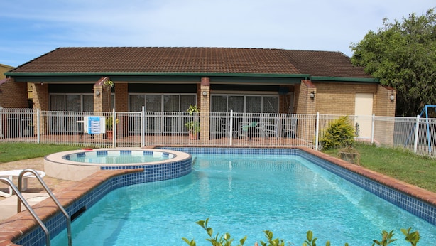 A swimming pool with a hot tub, surrounded by a fenced patio area. - Sun Plaza Motel Mackay (West Mackay)